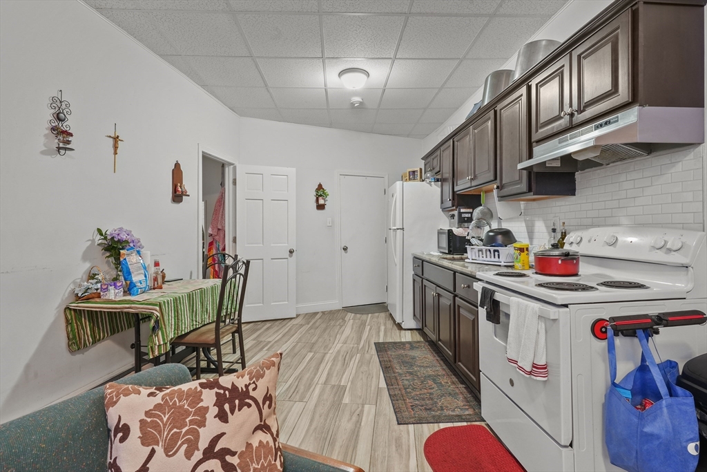 1792 Pleasant Street Fall River, MA 02723 - Photo 8 of 32 a kitchen that has a lot of cabinets a sink and wooden floor
