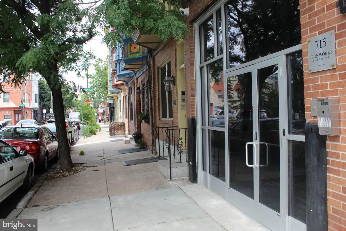 a view of a house with a cars park side of a road