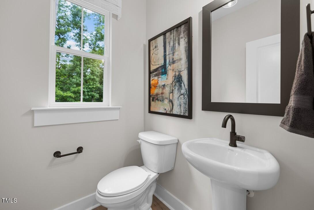 4713 Mint Leaf Lane Raleigh, NC 27612 - Photo 23 of 43 a bathroom with a toilet sink and mirror