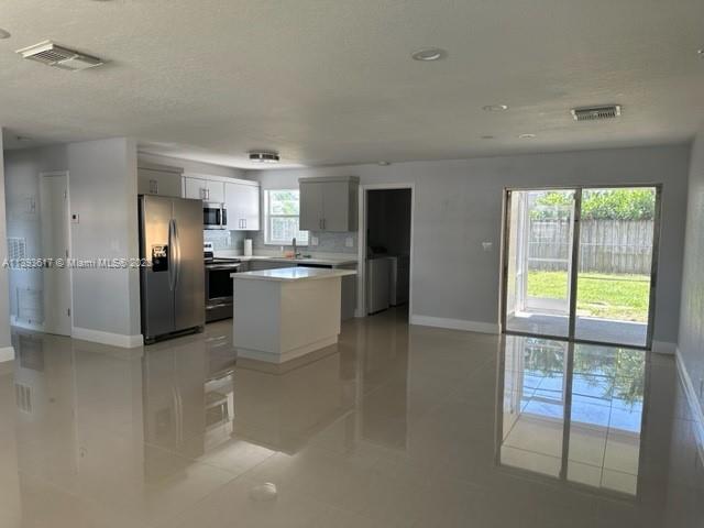 1472 Northeast 62nd Street, Unit 1472 Fort Lauderdale, FL 33334 - Photo 15 of 19 a kitchen with stainless steel appliances granite countertop a refrigerator and a stove top oven