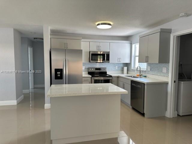 1472 Northeast 62nd Street, Unit 1472 Fort Lauderdale, FL 33334 - Photo 3 of 19 a kitchen with cabinets and stainless steel appliances