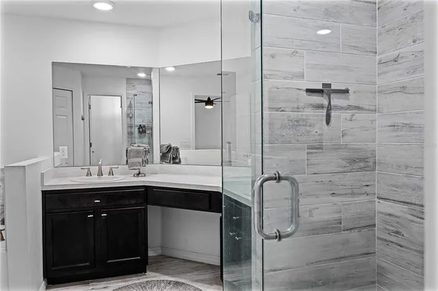 a bathroom with a double vanity sink a toilet and shower