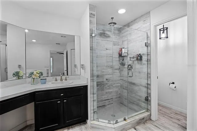 a bathroom with a shower sink and mirror