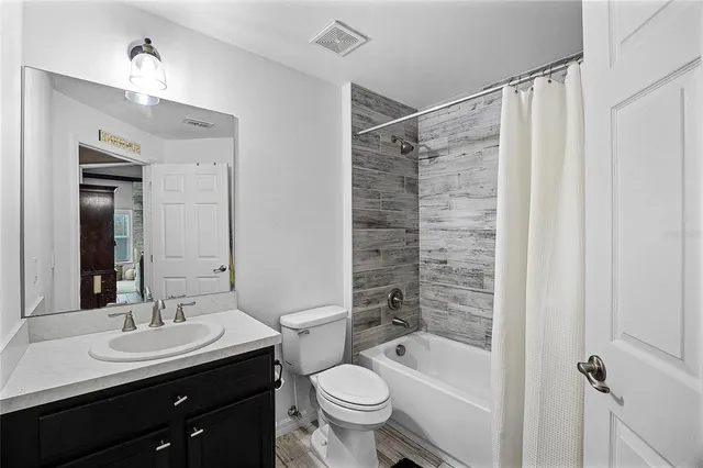 a bathroom with a sink a toilet a mirror and shower