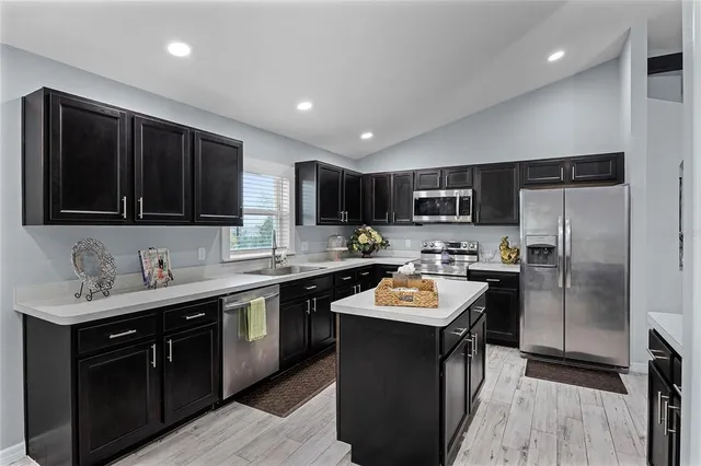 a kitchen with a sink a stove a refrigerator and cabinets