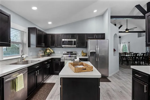 a kitchen with a sink a kitchen island a stove a refrigerator cabinets and a center island