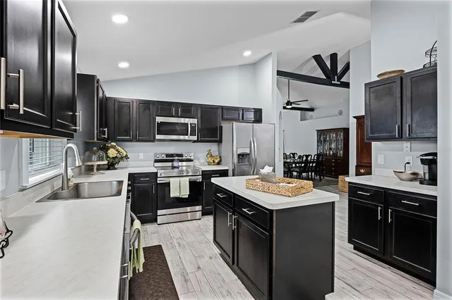 a kitchen with stainless steel appliances granite countertop a sink stove oven and refrigerator