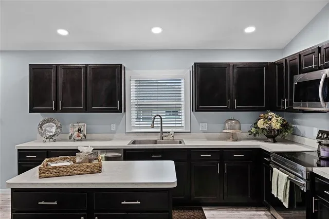 a kitchen with a sink and a stove top oven with wooden floor