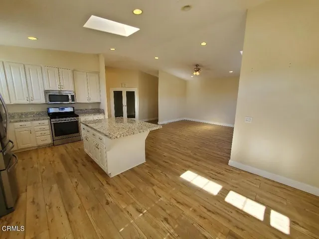 a kitchen with granite countertop a refrigerator and a stove top oven