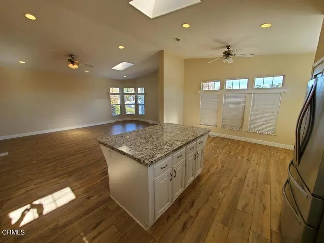 a large room with kitchen island granite countertop a large counter top stainless steel appliances and cabinets