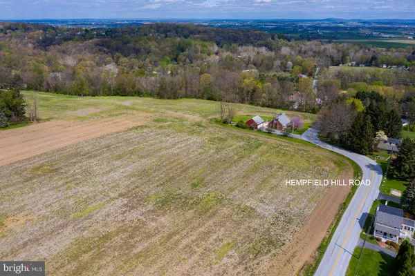 an aerial view of a houses with a yard and lake view