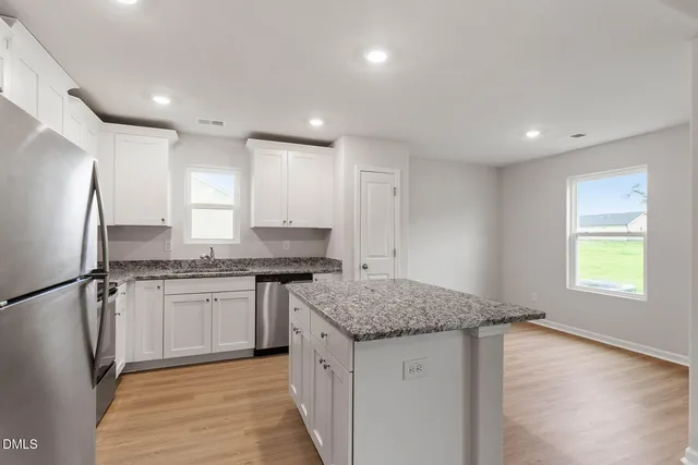 a kitchen with granite countertop a sink stove and refrigerator