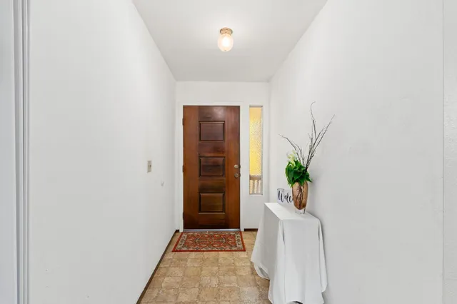 a living room with furniture a flat screen tv and floor to ceiling window