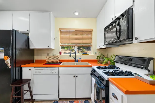 a kitchen with stainless steel appliances a stove a sink and a refrigerator