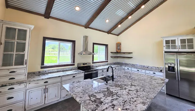 a kitchen with stainless steel appliances kitchen island granite countertop a sink stove and cabinets