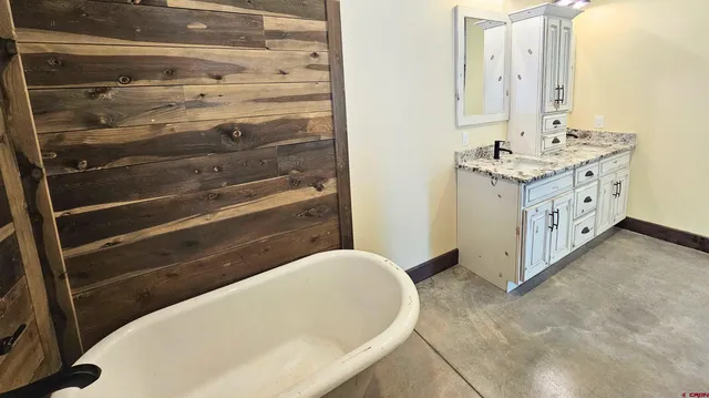 a bathroom with a tub sink and mirror