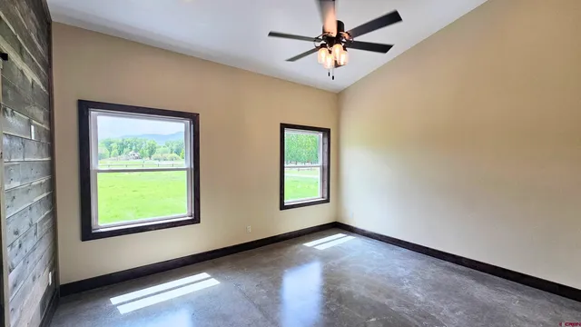 an empty room with closet and a chandelier fan