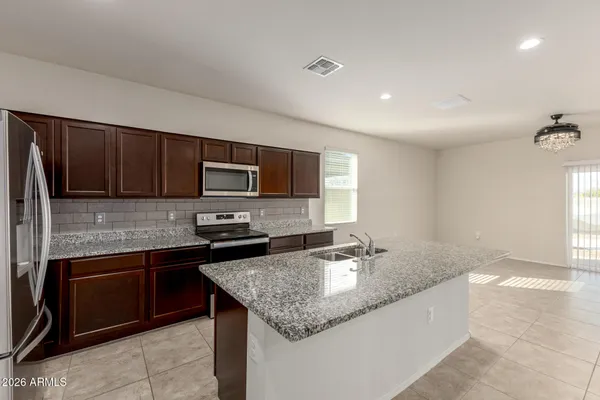 a kitchen with stainless steel appliances granite countertop a sink refrigerator and microwave