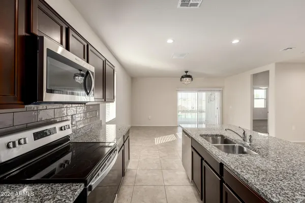 an empty room with windows and chandelier fan