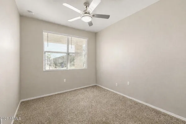 a view of an empty room and a chandelier fan