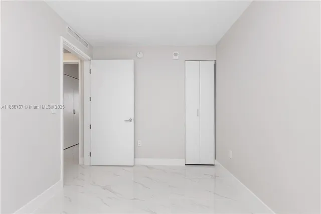 a bedroom with furniture and large windows