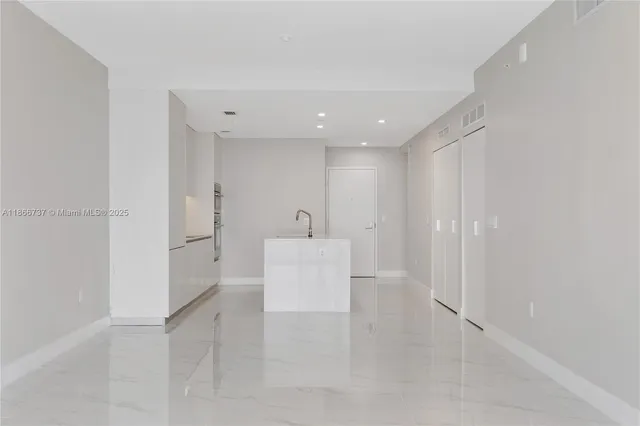 a kitchen with a sink and white cabinets