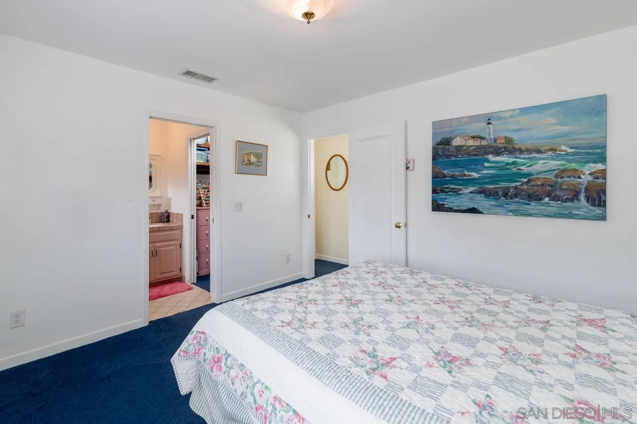 1295 Sunset Cliffs Boulevard San Diego, CA 92107 - Photo 23 of 32 a bedroom with a bed and a painting on the wall