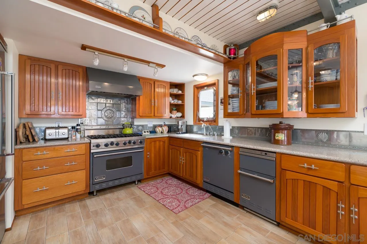 1295 Sunset Cliffs Boulevard San Diego, CA 92107 - Photo 25 of 32 a kitchen with stainless steel appliances granite countertop a stove and cabinets