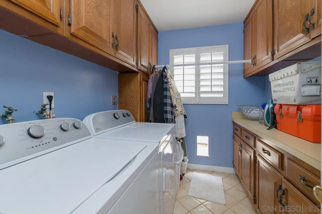 1295 Sunset Cliffs Boulevard San Diego, CA 92107 - Photo 10 of 32 a utility room with stainless steel appliances wooden cabinets washer and dryer