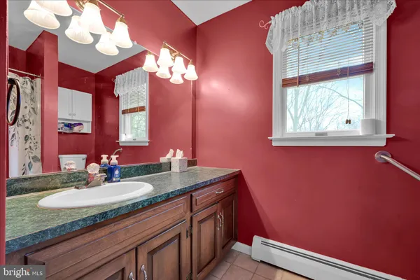 a bathroom with a granite countertop sink and a mirror
