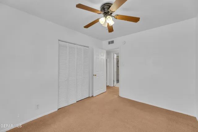 an empty room with chandelier fan