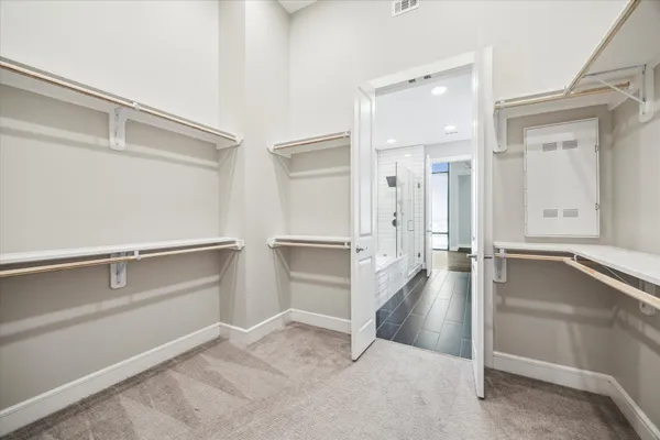 walk in closet with white walls