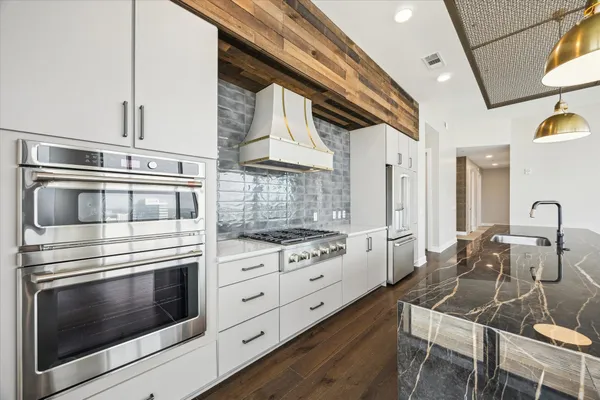 a kitchen with stainless steel appliances kitchen island granite countertop a stove and a sink