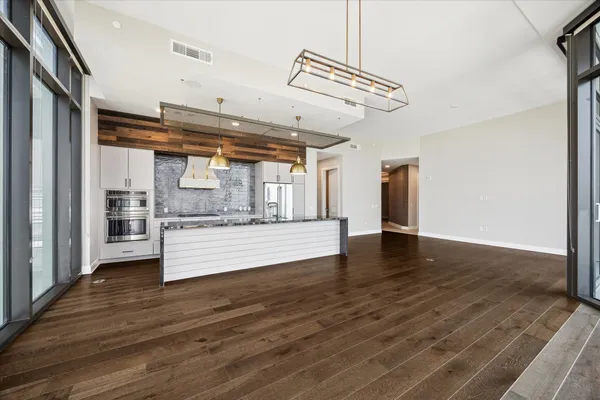a view of a kitchen with stainless steel appliances wooden floor