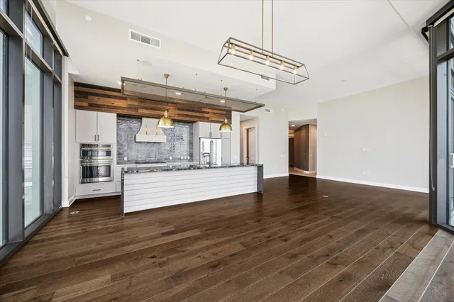a view of a kitchen with stainless steel appliances wooden floor
