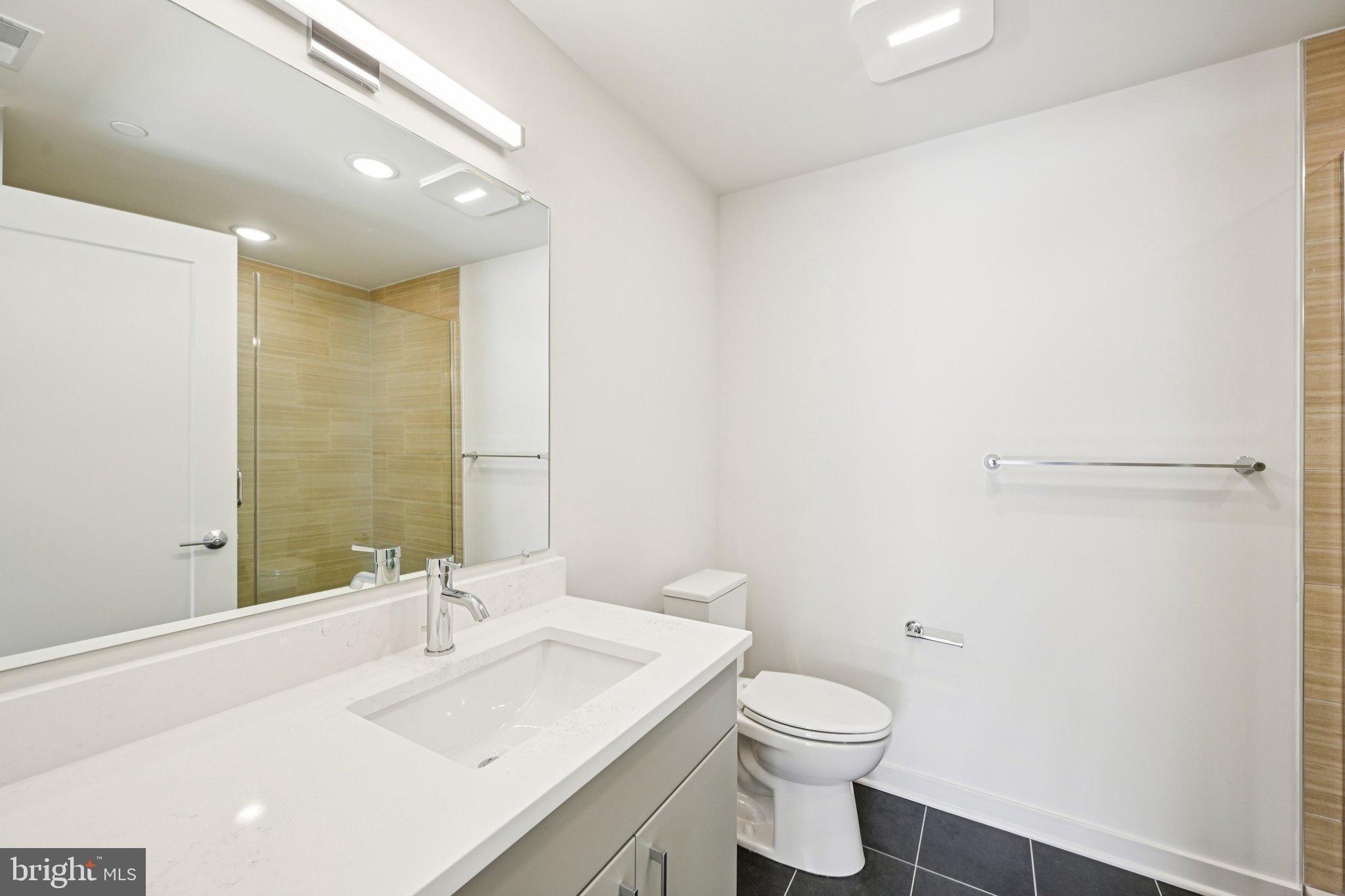 23 Rock Hill Road, Unit 201 Bala Cynwyd, PA 19004 - Photo 5 of 8 a bathroom with a sink a toilet and shower