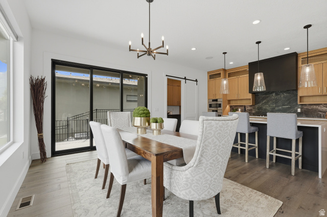653 East Vandalay Lane Draper, UT 84020 - Photo 17 of 61 Open-concept dining area with wood-finish flooring, a contemporary chandelier, and large sliding glass doors