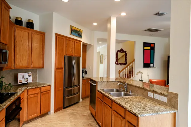 a kitchen with stainless steel appliances granite countertop a sink stove and refrigerator