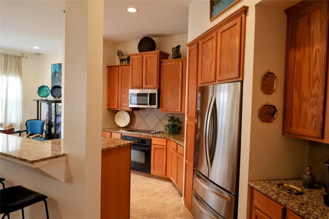 a kitchen with stainless steel appliances granite countertop a refrigerator and a stove