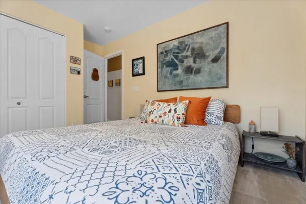 a bedroom with a bed and a painting on the wall