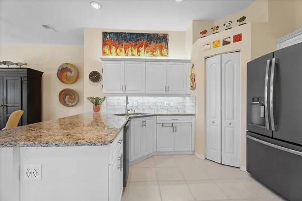 a kitchen with stainless steel appliances granite countertop a refrigerator and a sink
