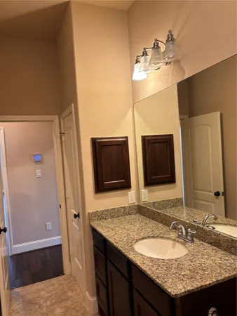 a bathroom with a granite countertop sink and a mirror