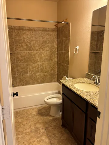 a bathroom with a granite countertop bathtub toilet and sink