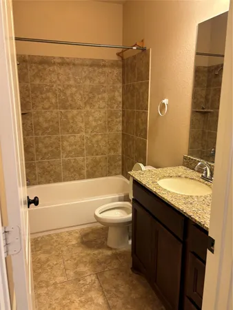 a bathroom with a granite countertop bathtub toilet and sink