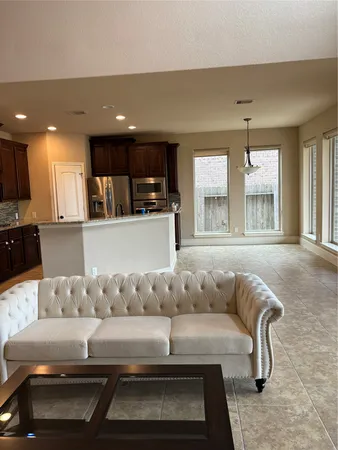 a living room with furniture and kitchen