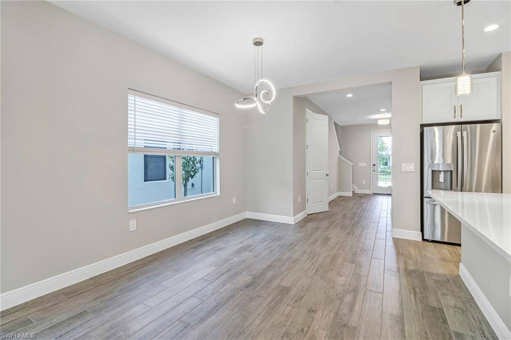4652 Centaurus Circle Naples, FL 34120 - Photo 7 of 45 Unfurnished dining area featuring light wood-style floors and baseboards