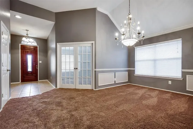 a view of a livingroom with a chandelier fan and windows
