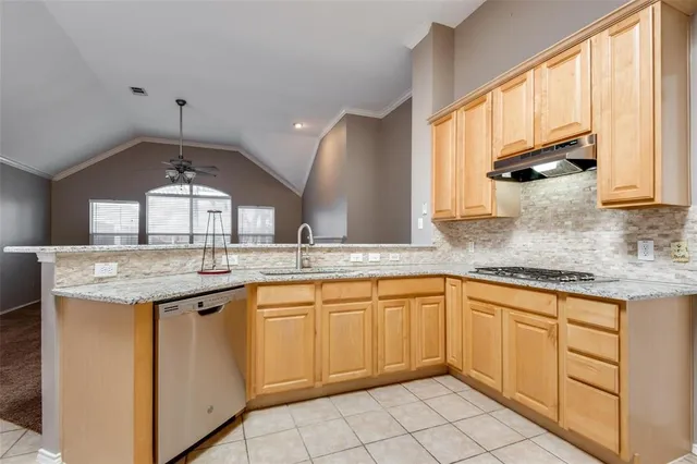 a kitchen with granite countertop a sink window and cabinets