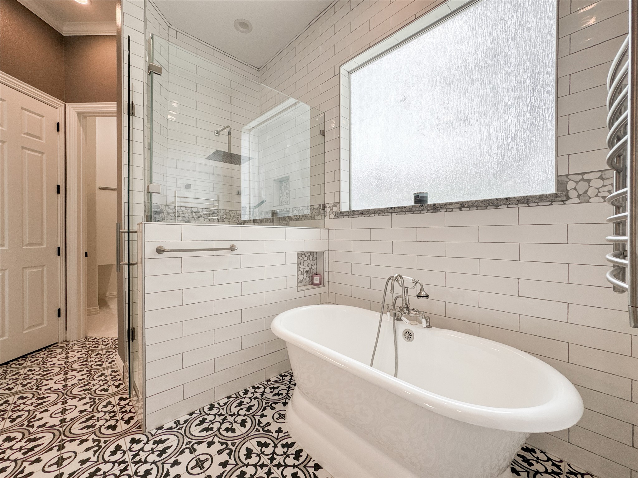 1810 Woerner Road Houston, TX 77090 - Photo 24 of 39 This elegant bathroom features a luxurious freestanding tub, a spacious glass-enclosed shower, and stylish patterned tile flooring, creating a serene spa-like retreat.