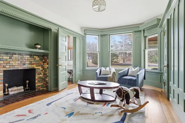 a living room with furniture a fireplace and a floor to ceiling window